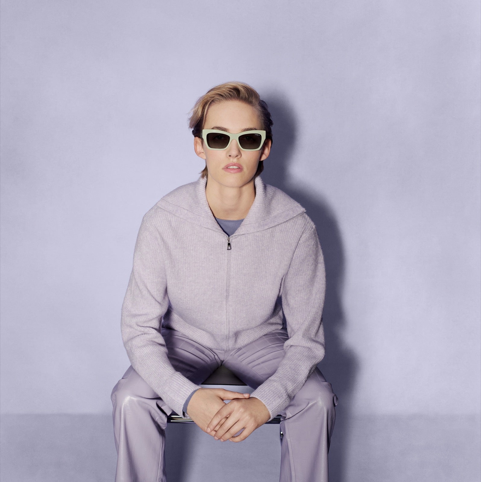 Model wearing mint sunglasses against a lavender backdrop
